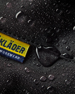 Bläkläder workwear label on a rain-soaked surface