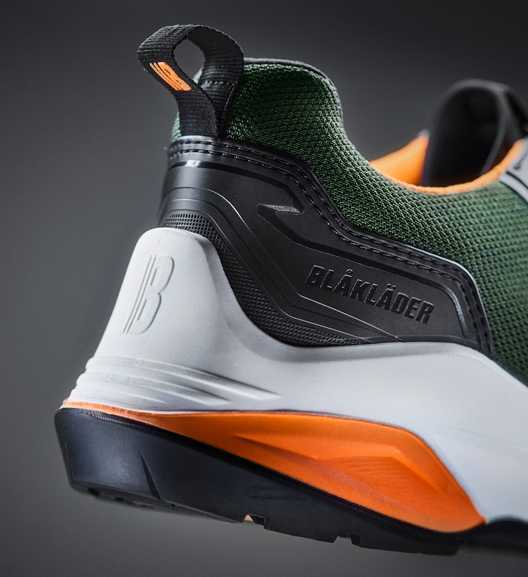 Green and orange shoe with 'Blåkläder' branding on a dark background