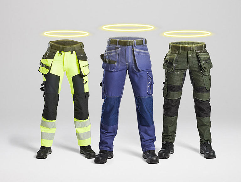 Three pairs of work pants in different colors on a gray background
